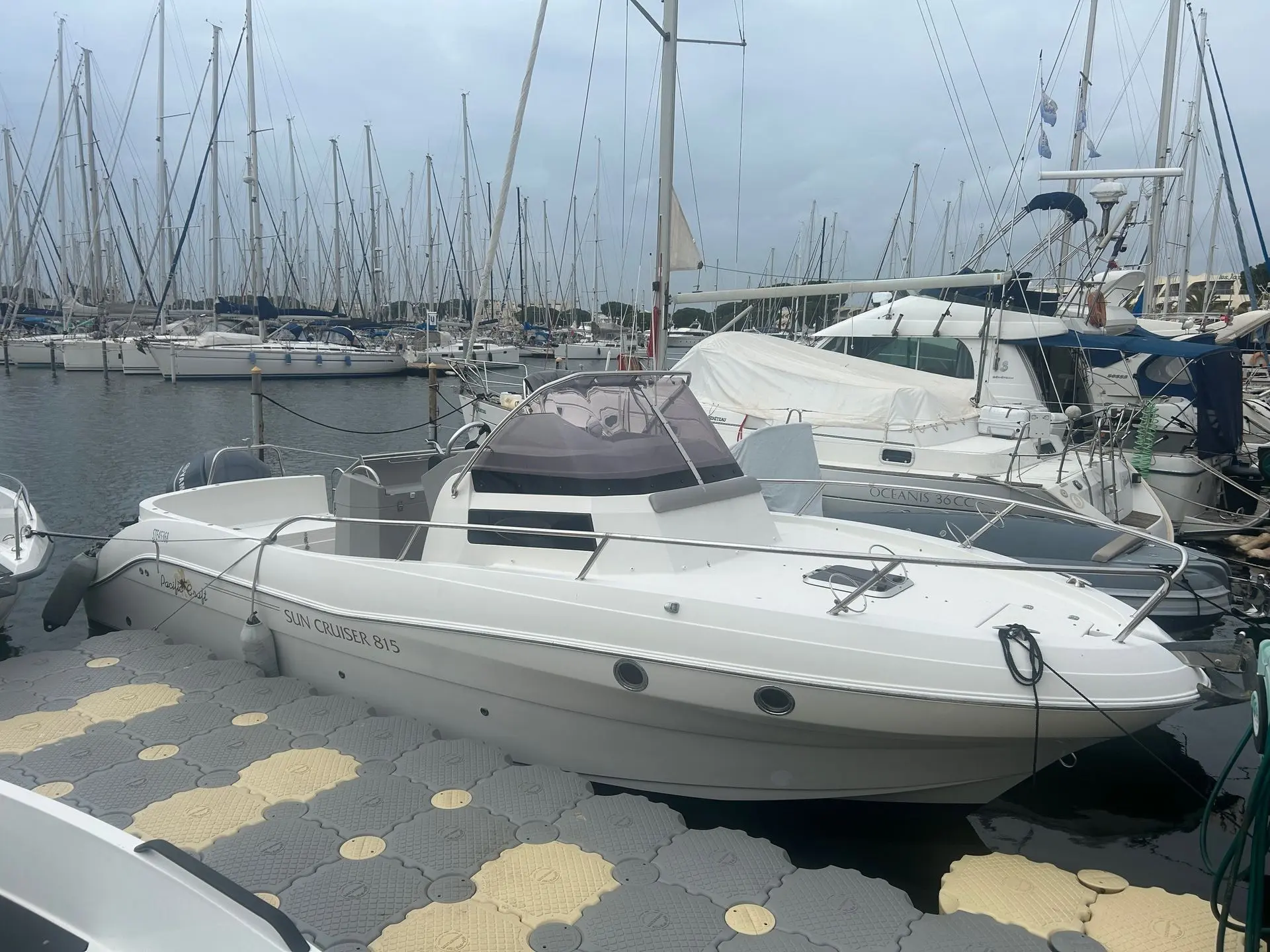 Pacific Craft 815 SC — Bateau à moteur blanc amarré dans un port de plaisance.