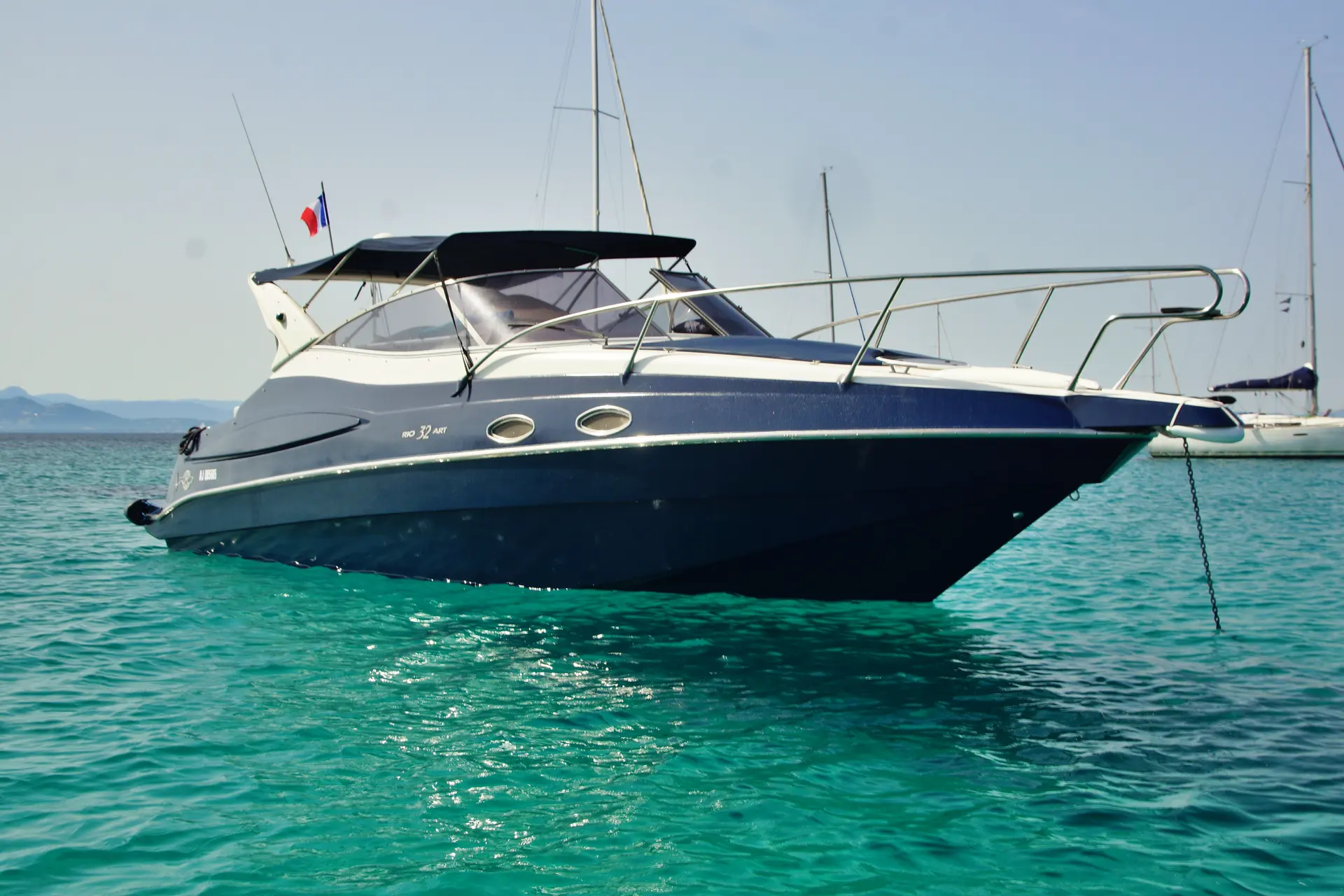 Rio 32 ART — Vue de profil trois quarts d’un bateau à moteur amarré dans une baie.