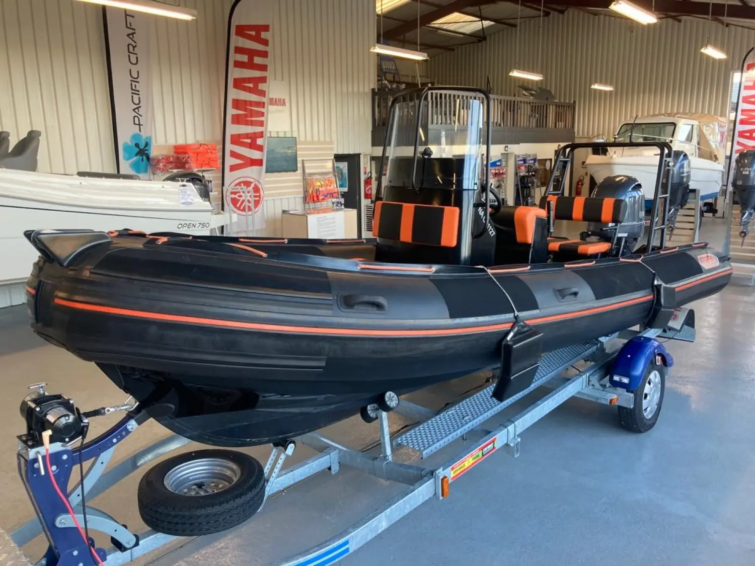 Zeppelin 22 VPRO — Bateau semi-rigide noir et orange présenté sur sa remorque dans un showroom.