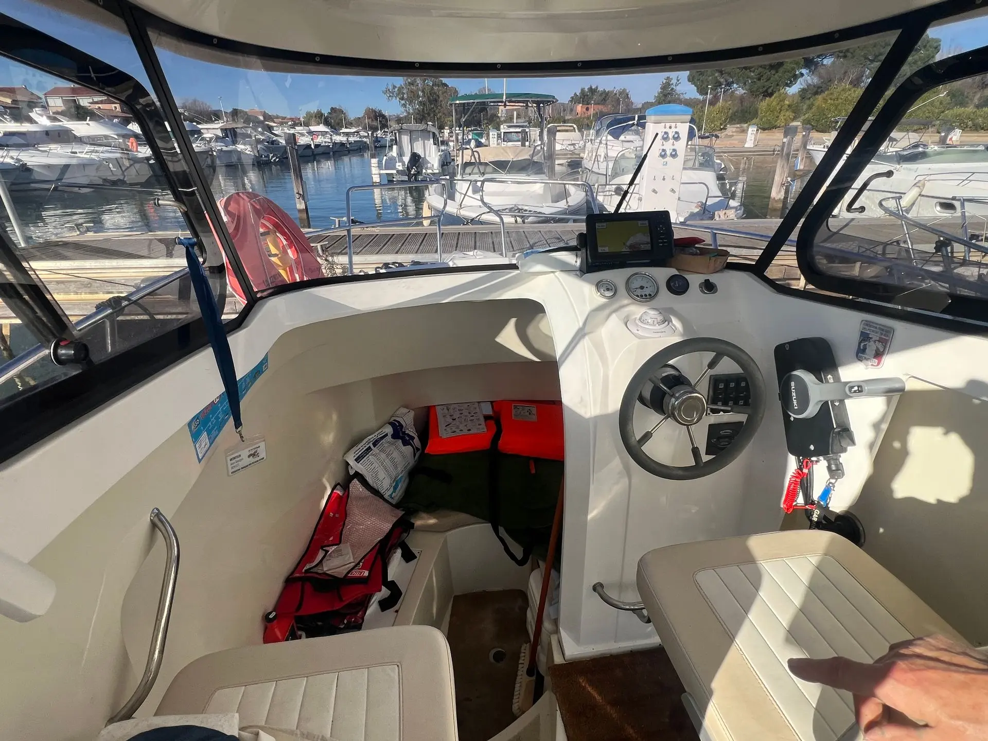 Rio 650 Coral — Poste de pilotage intérieur avec volant, instruments et équipements de sécurité.