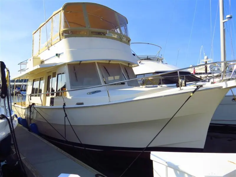 Mainship 400 Expedition — Bateau à moteur blanc amarré dans une marina, vu de trois quarts avant.