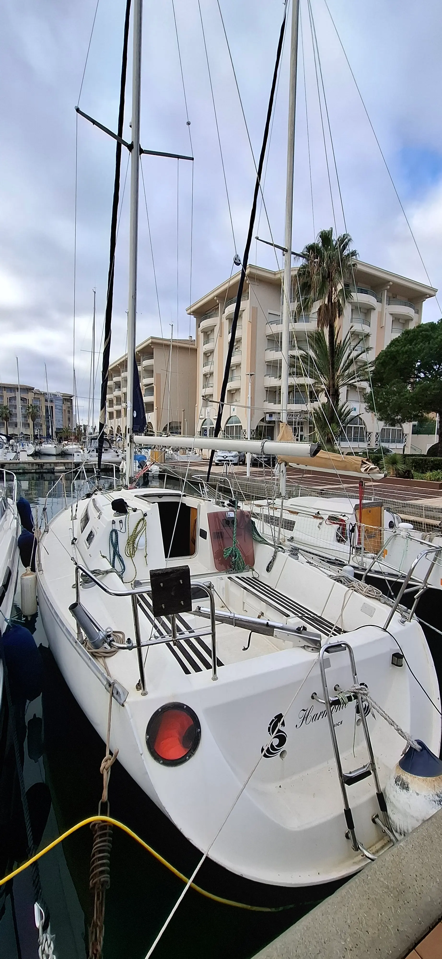 Beneteau First 285 — Voilier blanc amarré dans une marina, photographié depuis l’arrière.