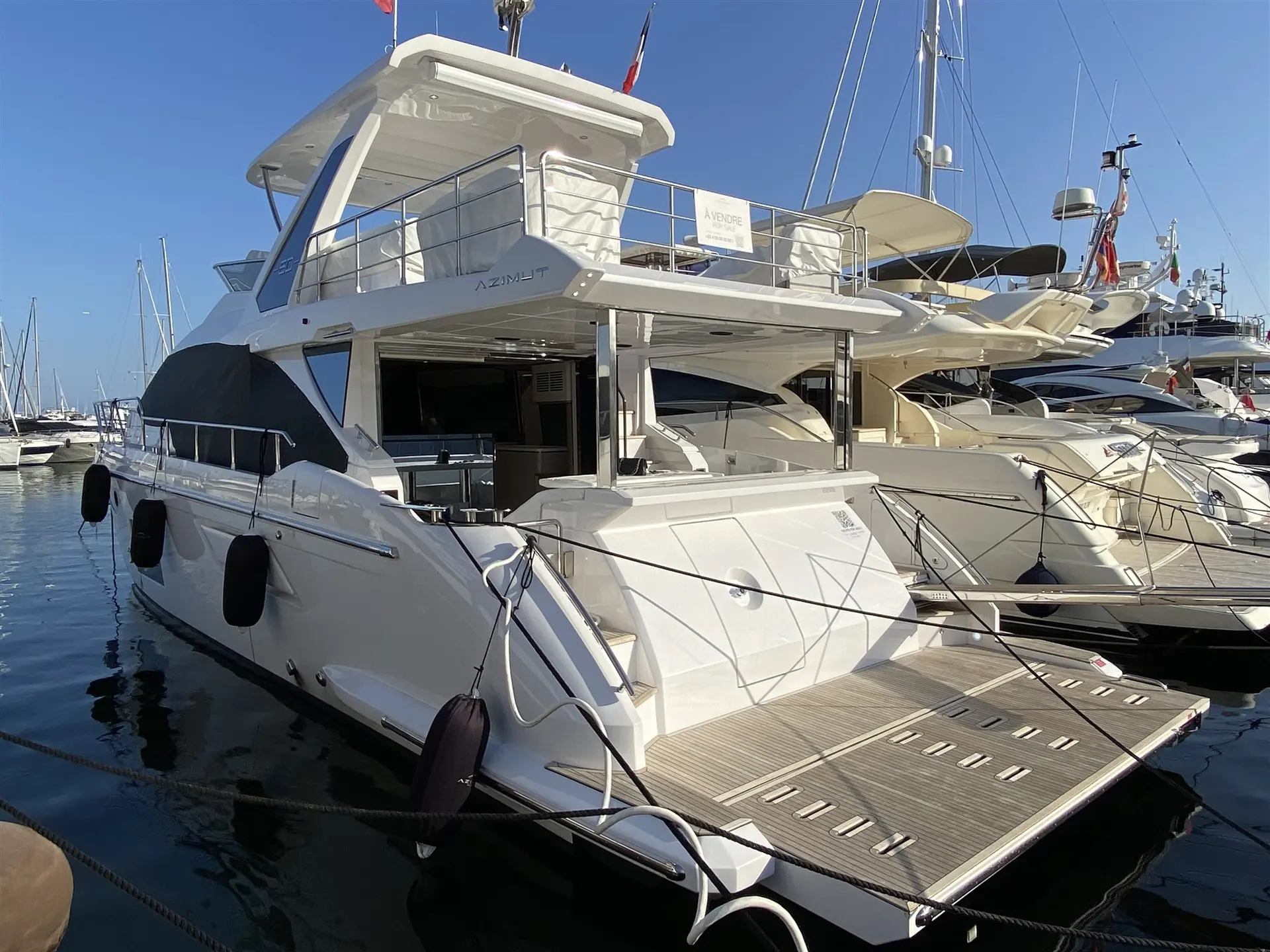 Azimut 60 Fly — Bateau à moteur blanc amarré dans un port de plaisance.