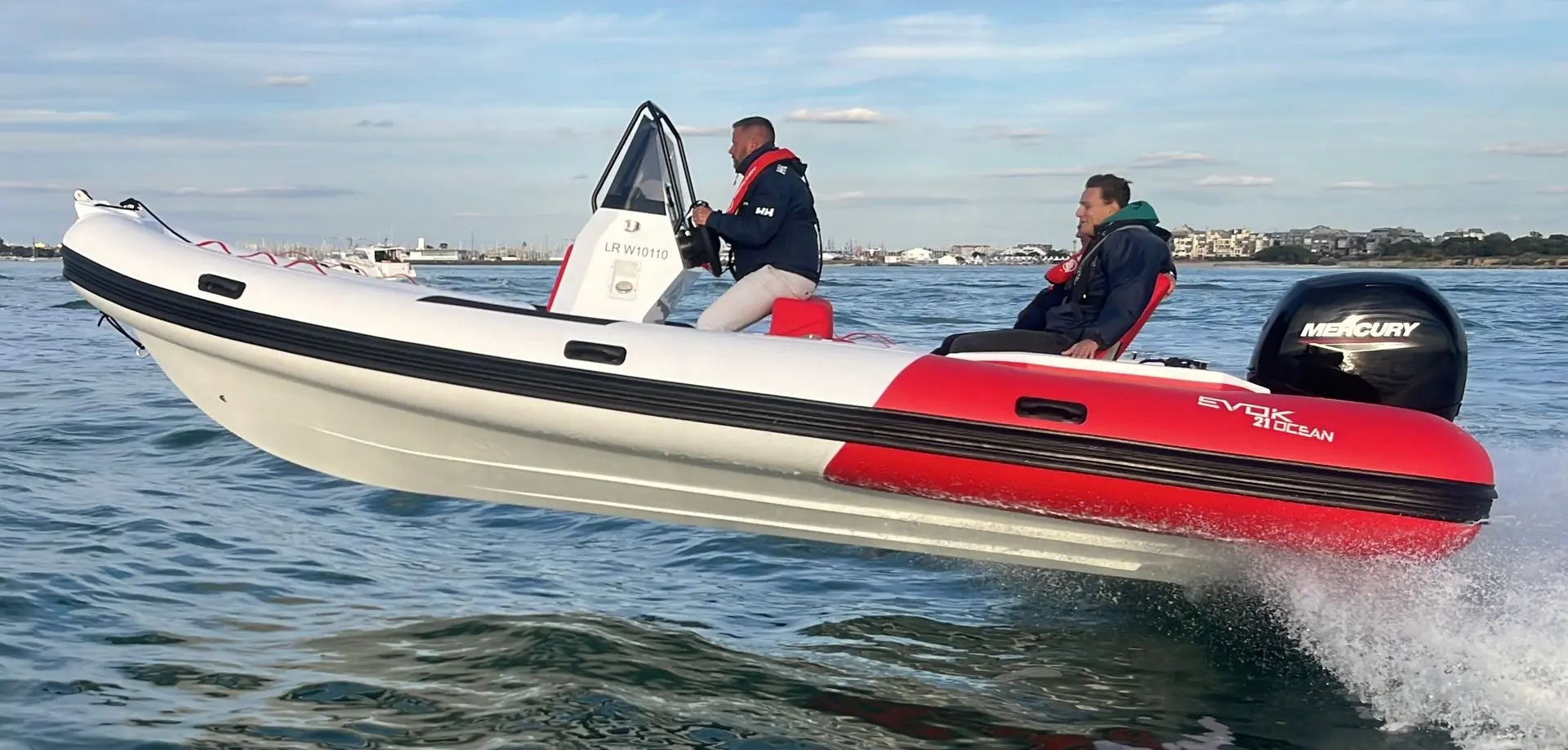 Evok Marine Evok 21 Ocean — Bateau semi-rigide blanc et rouge naviguant au large avec deux occupants.