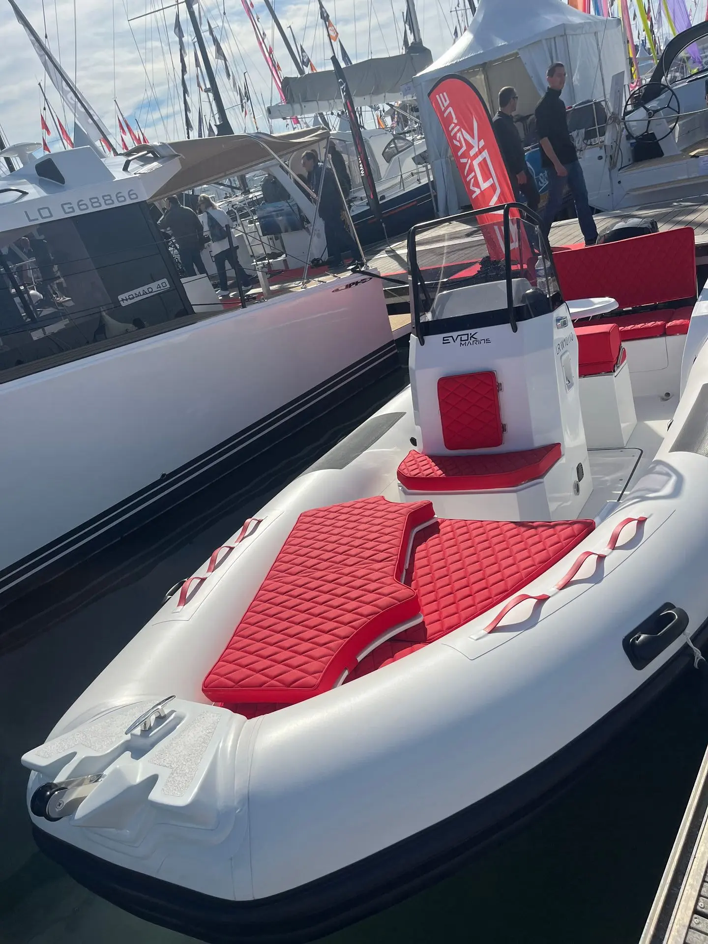 Evok Marine Evok 21 Ocean — Vue d’un bateau pneumatique blanc et rouge amarré dans un salon nautique.