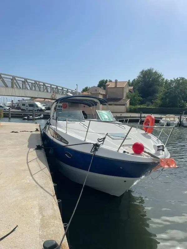 Bayliner 325 — Bateau à moteur amarré au ponton, photographié de trois quarts avant.
