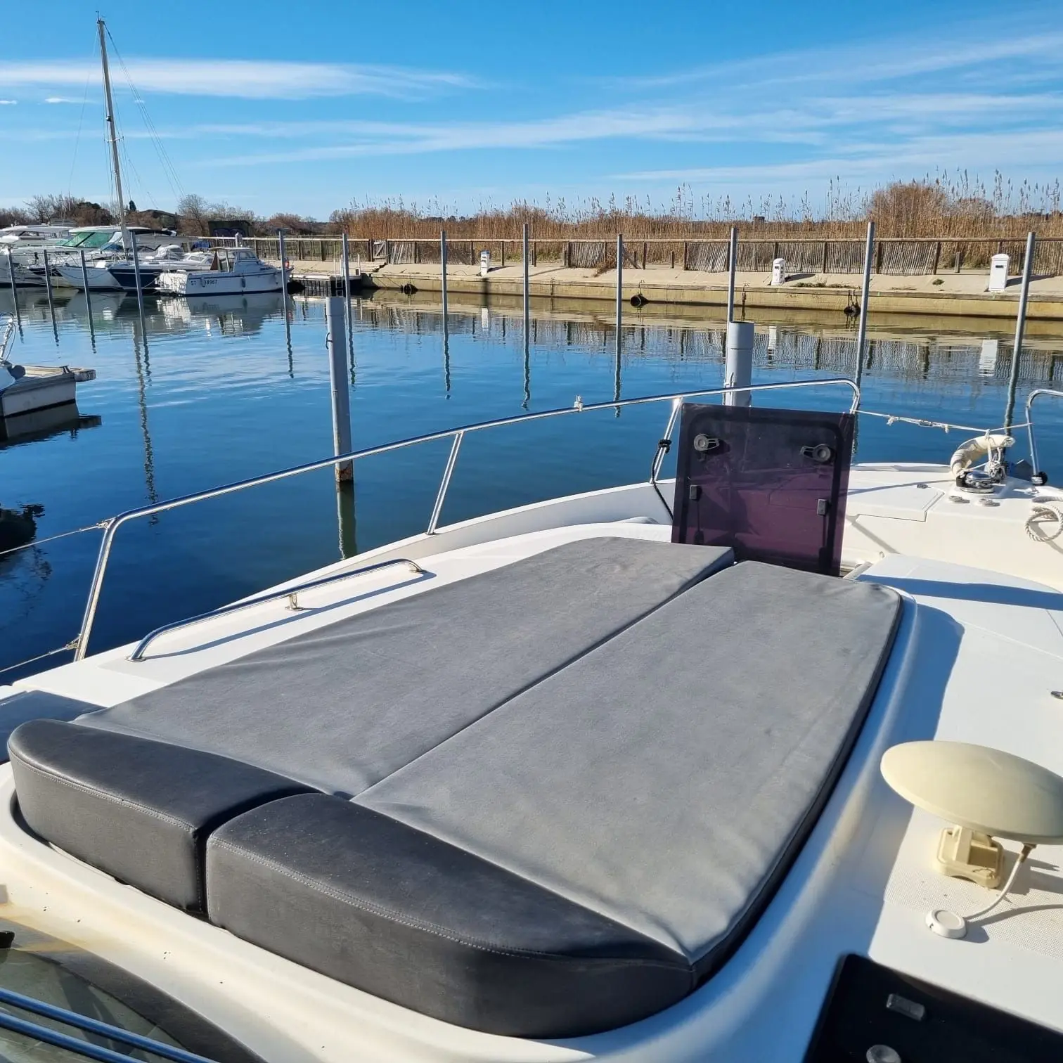 Delphia 1080 Soley — Vue du bain de soleil avant d’un bateau amarré dans un port.