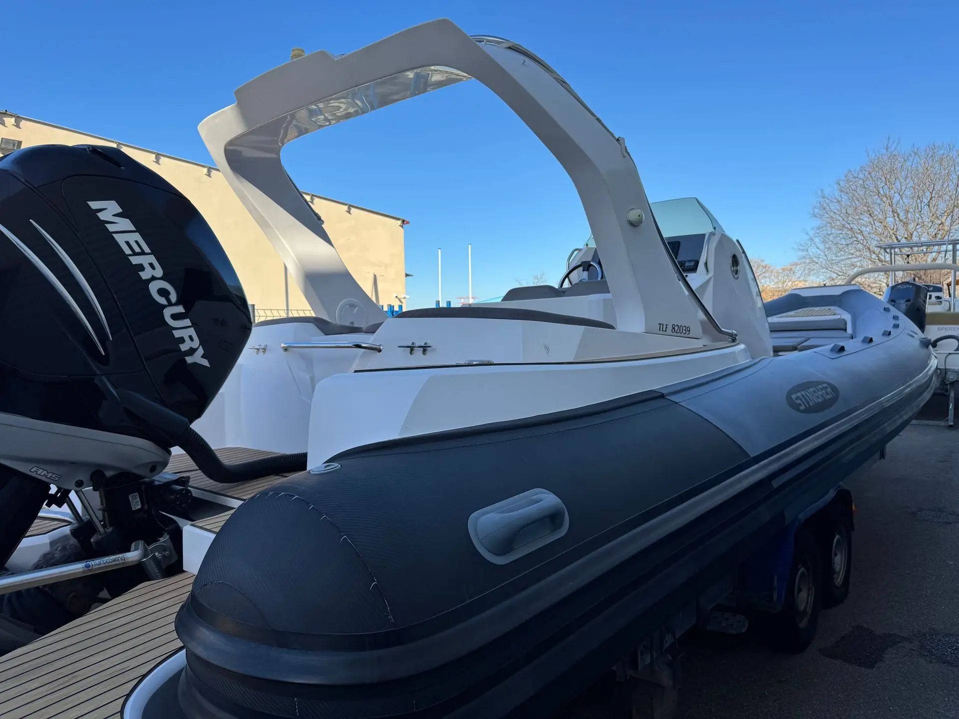 Stingher 30 GT — Vue latérale d’un bateau pneumatique blanc et noir équipé d’un moteur hors-bord.