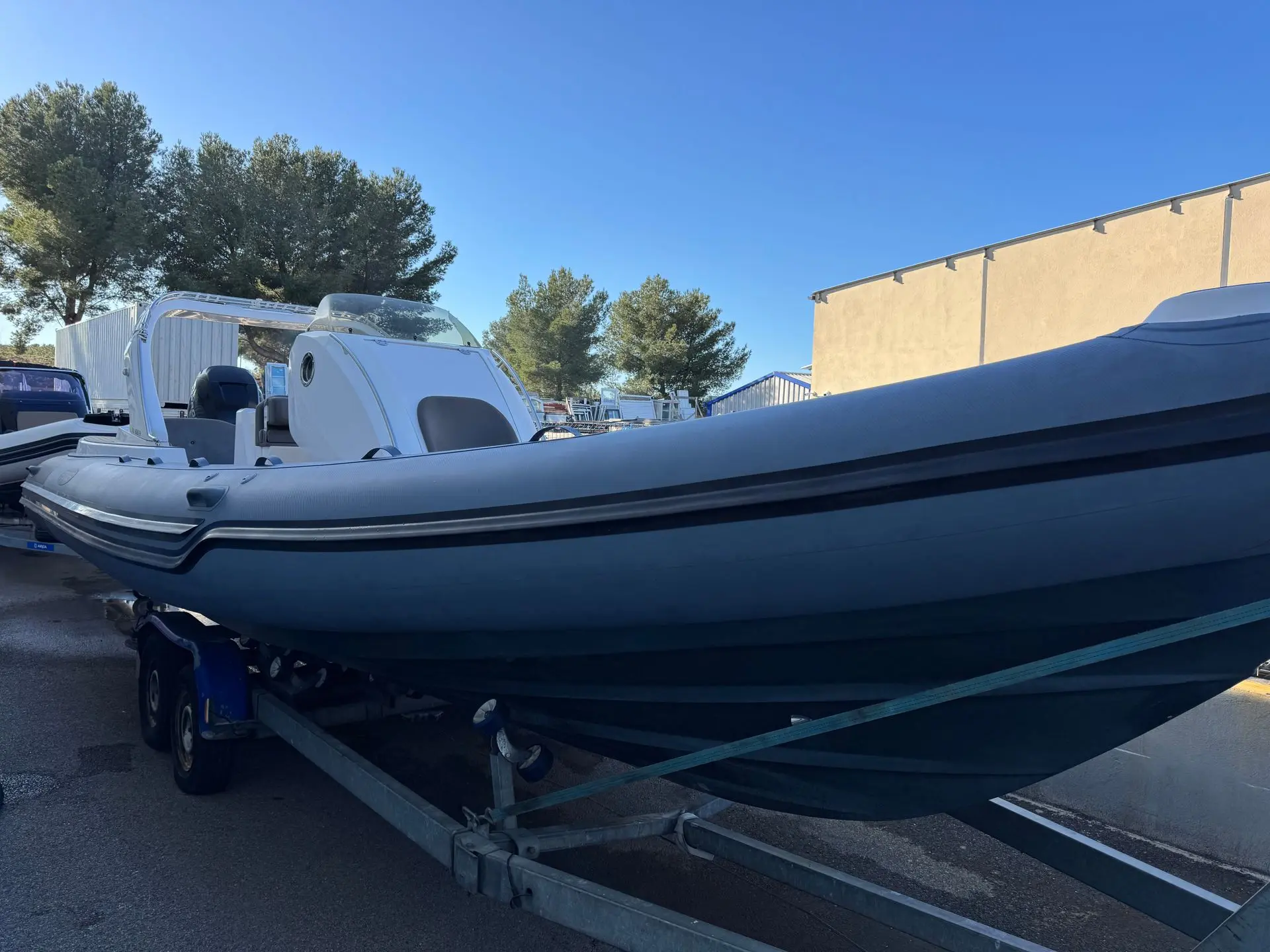 Stingher 30 GT — Bateau pneumatique semi-rigide gris présenté sur sa remorque à terre.