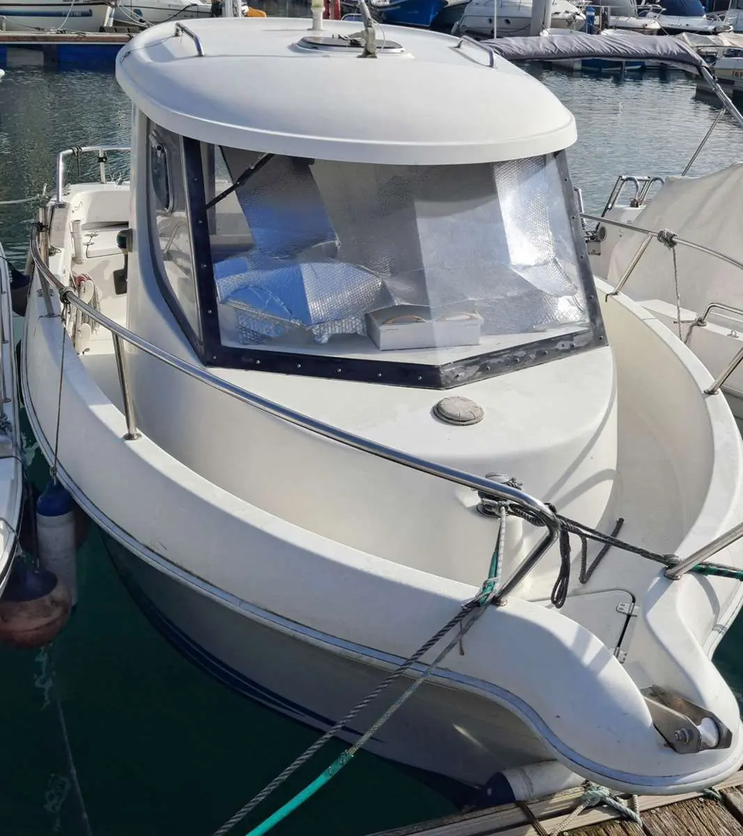 Baltic Yachts Arvor 18 — Vue rapprochée de l’avant d’un bateau à moteur amarré, avec cabine vitrée.