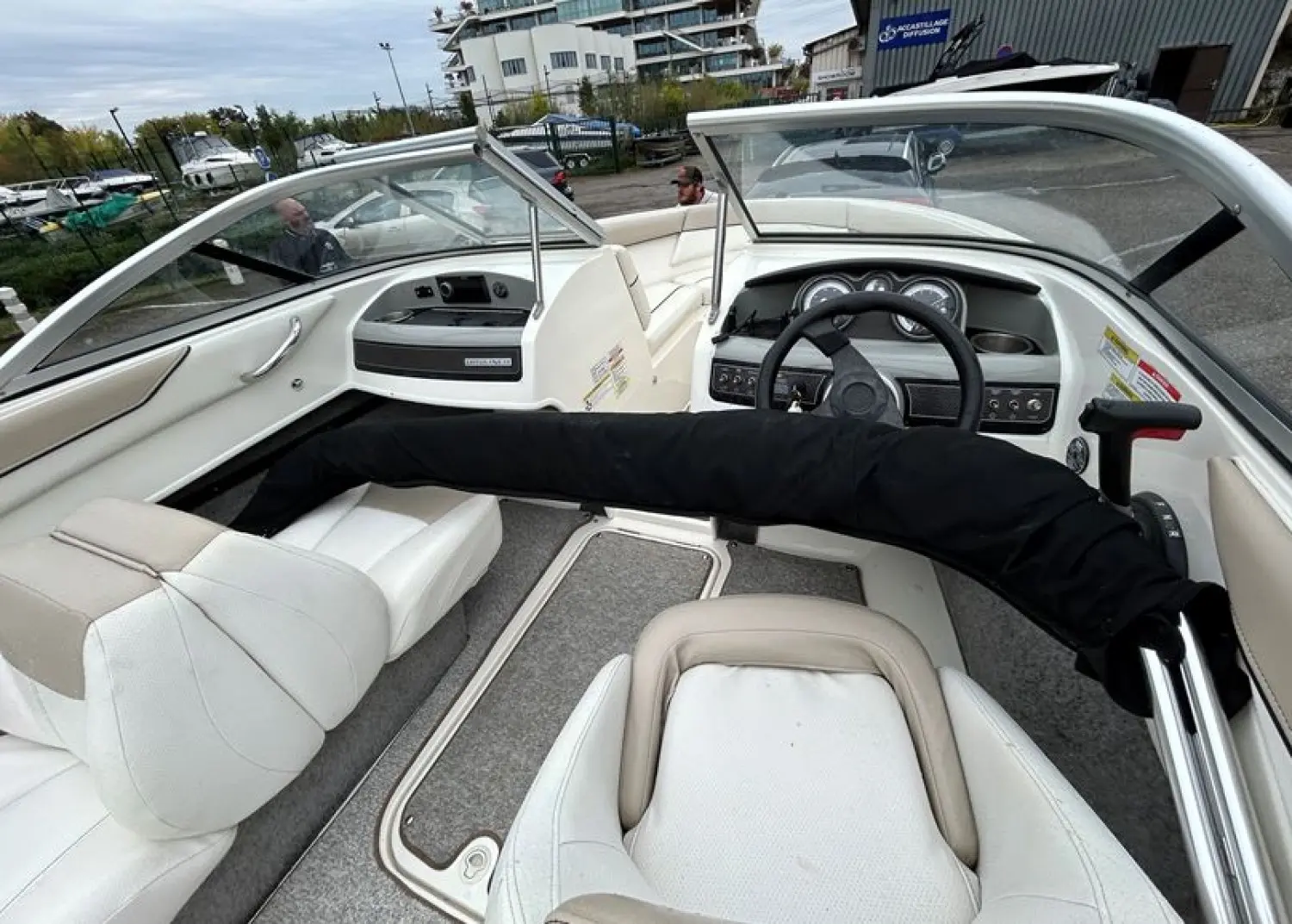 Bayliner 185 — Vue du poste de pilotage et des sièges avant d’un bateau sur terre.