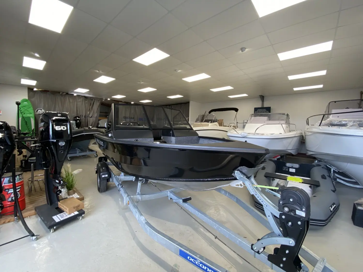 Powerboat 470 DC — Bateau noir à console centrale présenté sur une remorque dans un showroom.