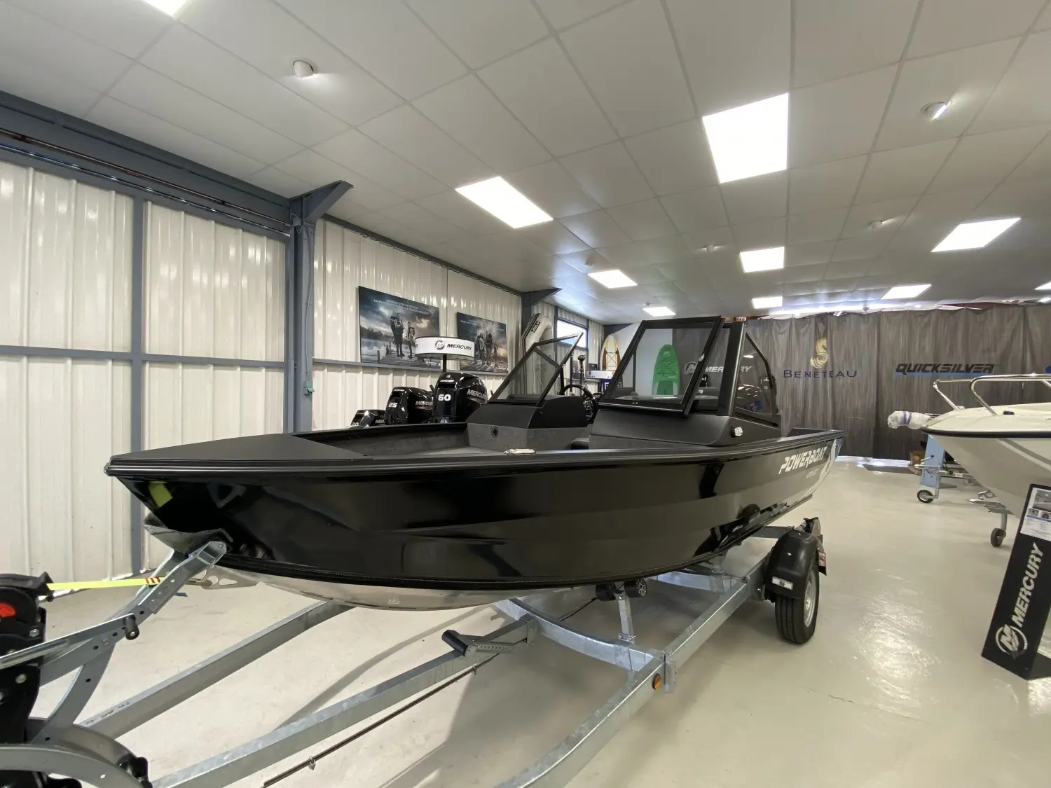 Powerboat 470 DC — Bateau noir présenté sur remorque dans un showroom nautique.