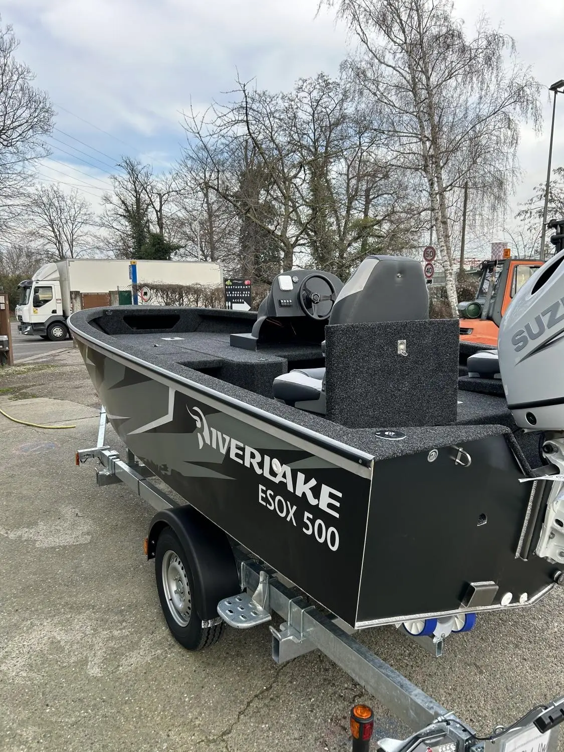Riverlake 500 Esox Sc — Bateau Riverlake Esox 500 gris présenté sur sa remorque avec moteur hors-bord.