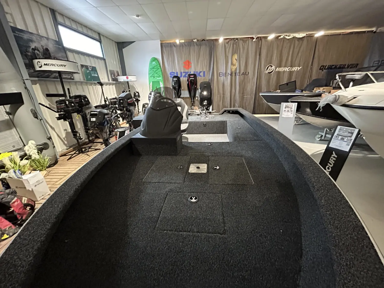 Riverlake 420 Fishing Machine — Vue du pont avant d’un bateau exposé dans un showroom nautique.