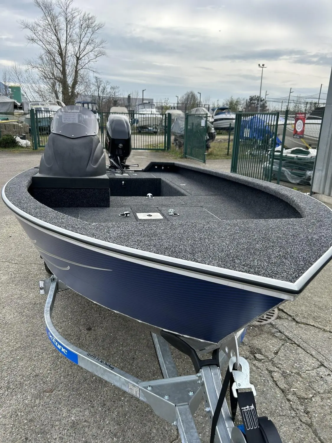 Riverlake 465 Fishing Machine — Bateau à moteur ouvert présenté sur une remorque dans une cour nautique.
