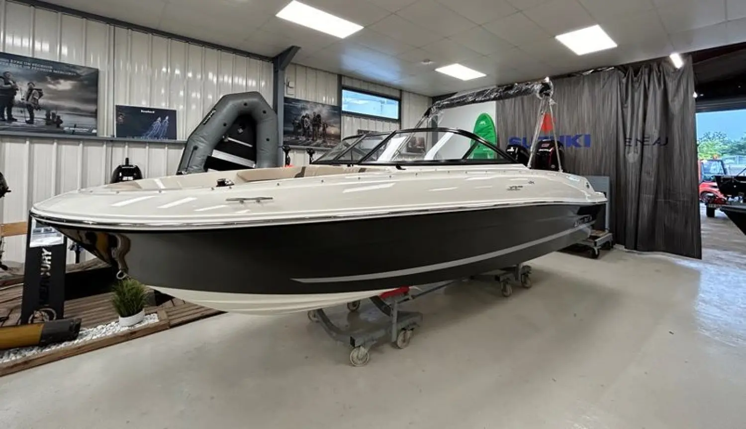 Bayliner VR4OE — Bateau blanc et noir présenté sur remorque dans un espace d’exposition intérieur.