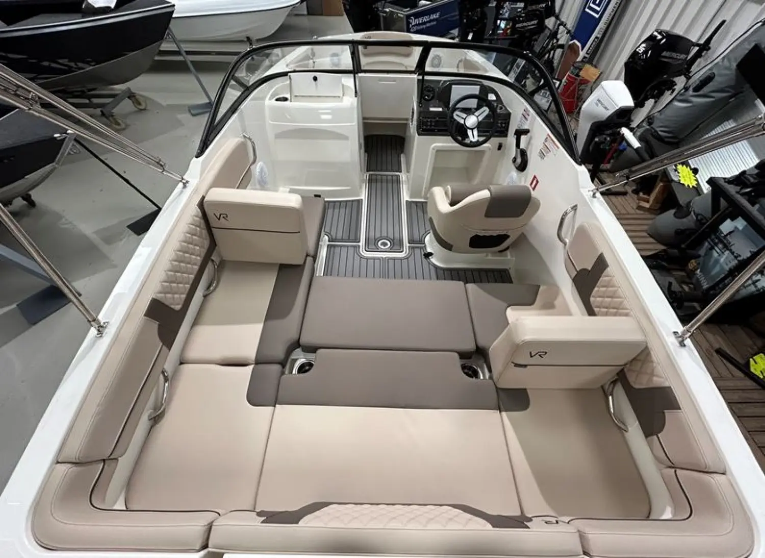 Bayliner VR4OE — Vue du cockpit et de la zone arrière d’un bateau exposé en intérieur.