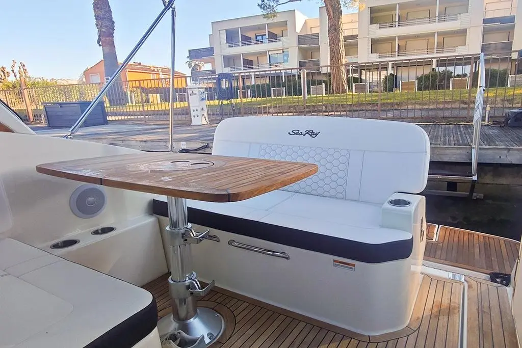 Sea Ray 265 Sundancer — Vue du cockpit avec banquette, table et plancher en teck.