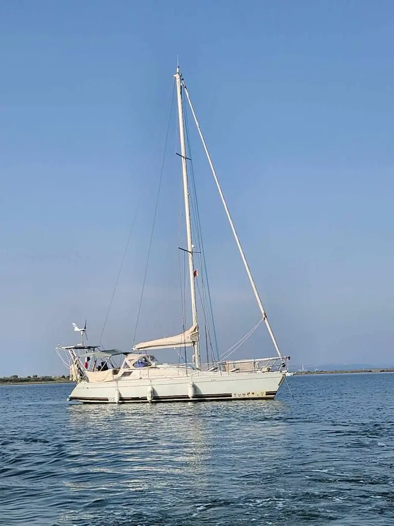 Kirie Feeling 1090 — Voilier blanc vu de profil sur une eau calme, sous un ciel dégagé.