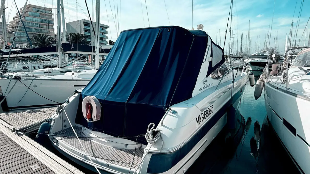 Bavaria 380 Sport Ht — Bateau à moteur blanc amarré dans une marina, vu de trois quarts arrière.
