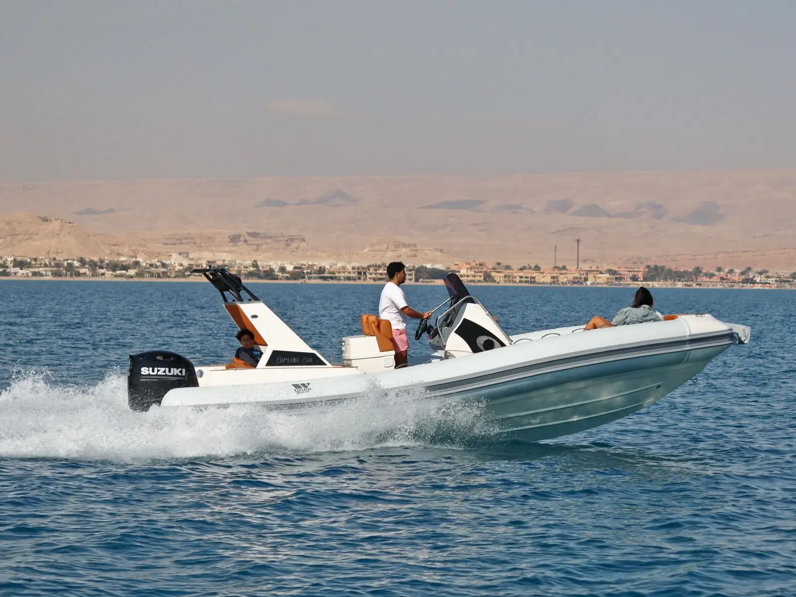Tiger Marine 750 TOP LINE — Bateau semi-rigide blanc naviguant à grande vitesse sur un plan d’eau.