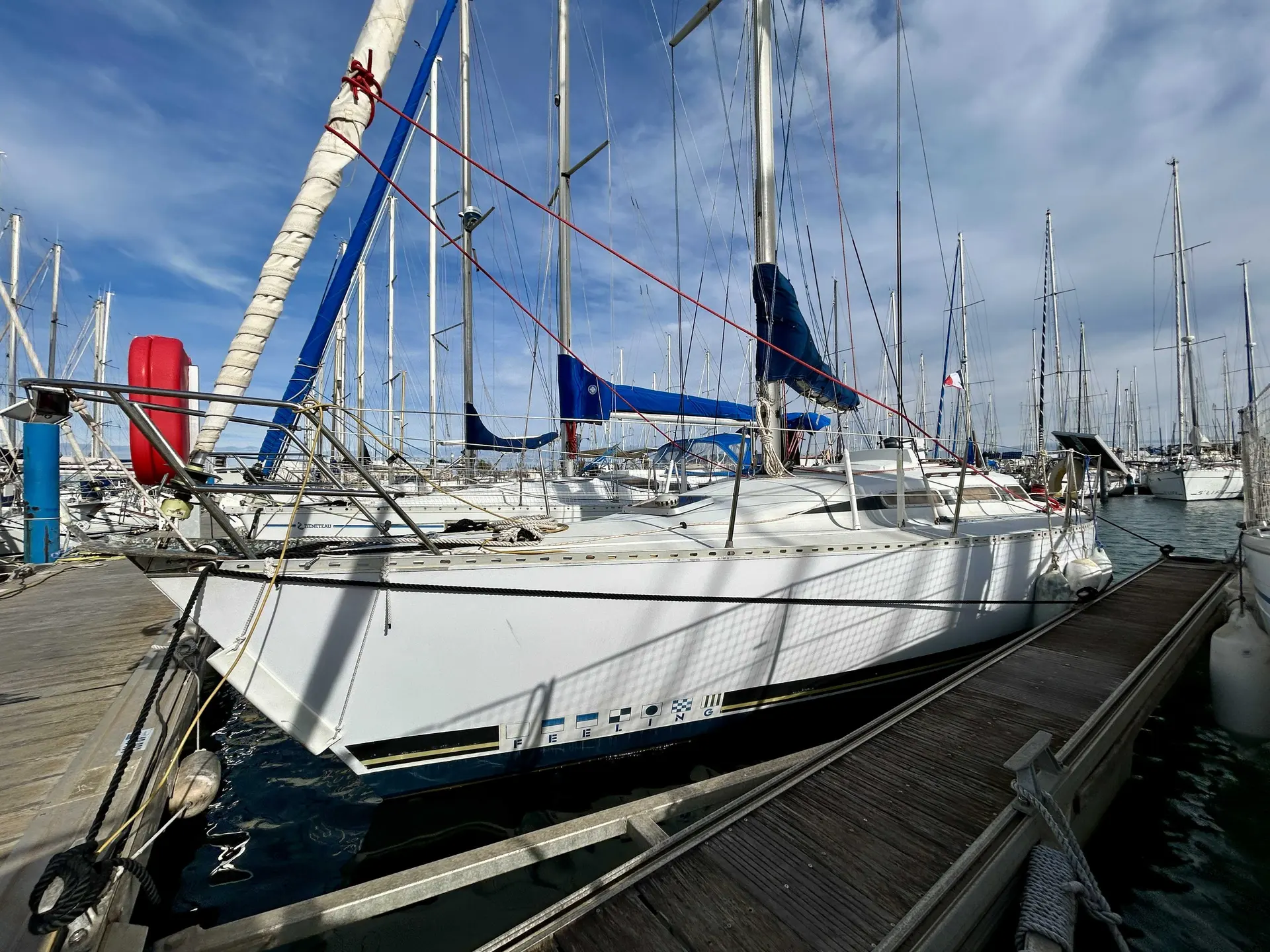 Kirie Feeling 960 — Voilier blanc amarré dans un port, photographié de trois quarts avant.