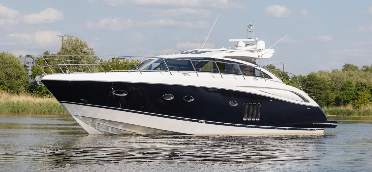 Princess V62 — Bateau à moteur vu de profil sur une voie d’eau, par temps dégagé.