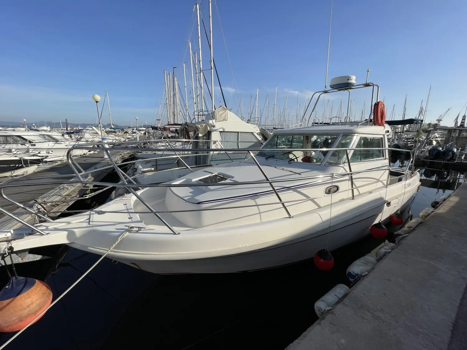 Faeton 910 Moraga — Bateau à moteur blanc amarré dans un port de plaisance, vu de trois quarts avant.