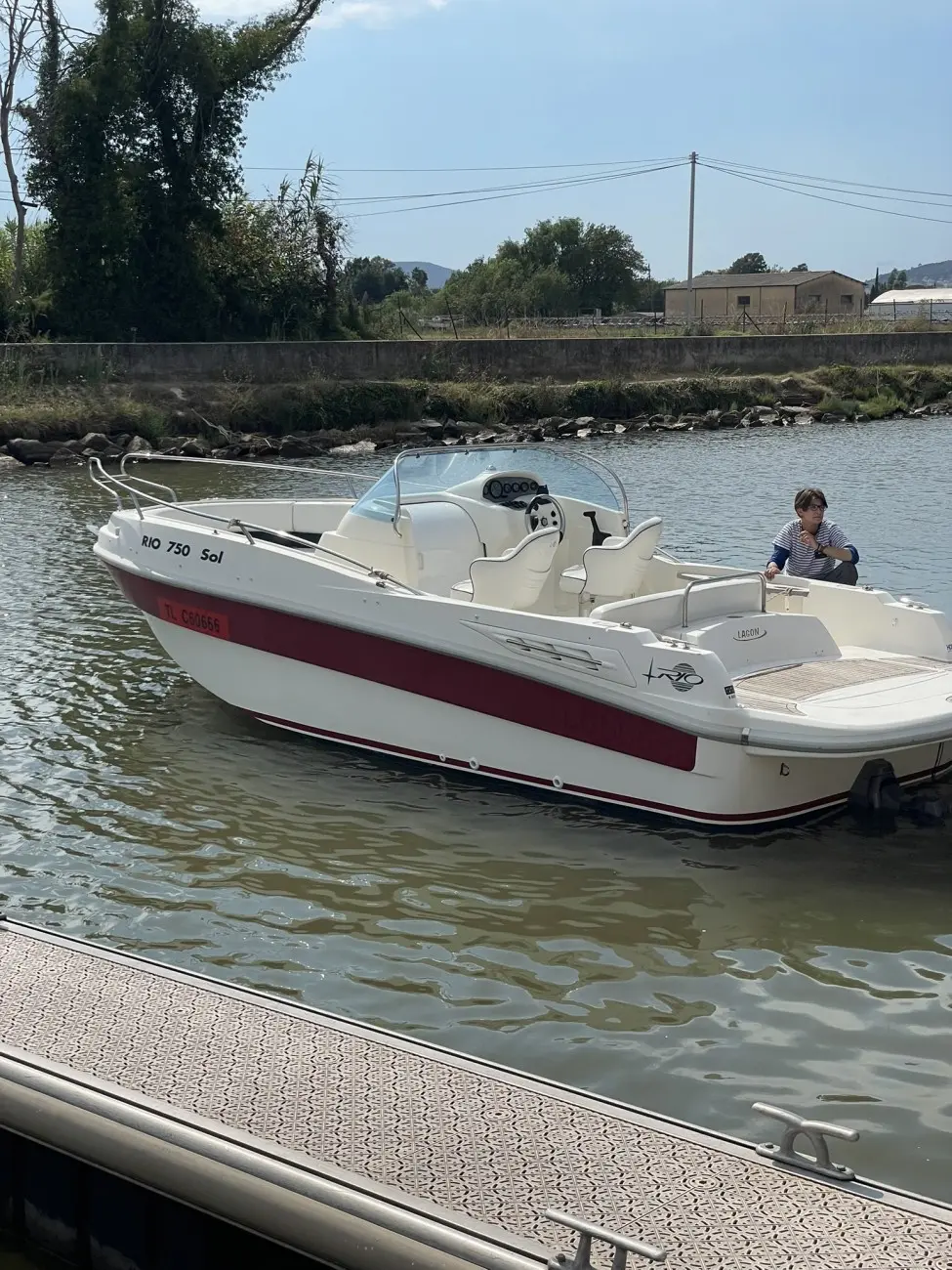 Rio 750 Sol — Bateau à moteur blanc et rouge amarré, photographié de trois quarts côté tribord.
