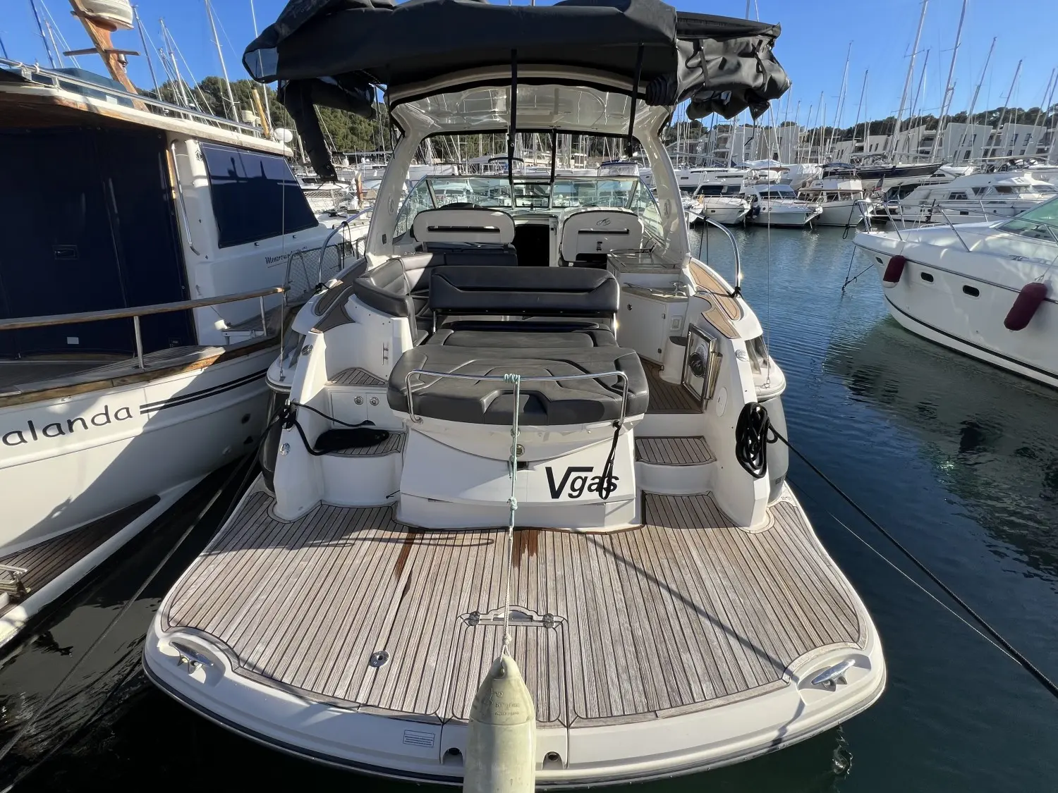 Monterey 415 SY — Vue arrière d’un bateau à moteur amarré dans une marina, avec cockpit et bain de soleil.