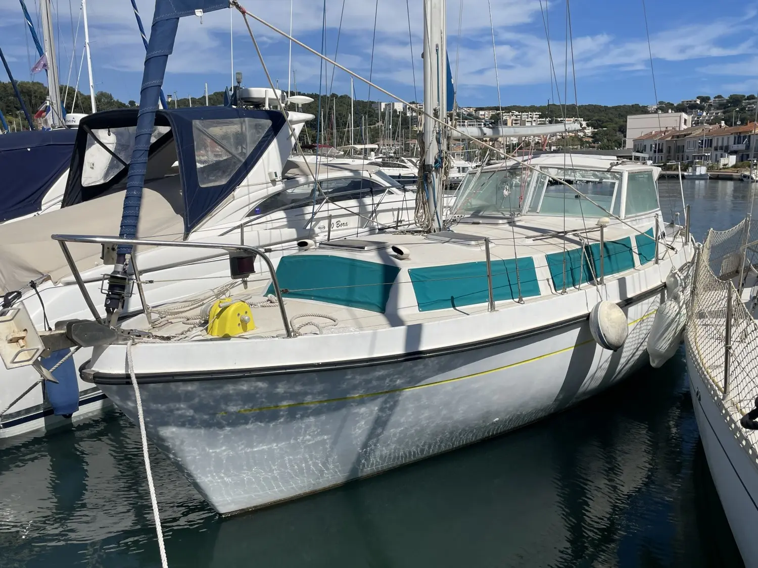 Kirie Fifty 33 — Voilier amarré dans un port, entouré d'autres bateaux et de bâtiments côtiers.