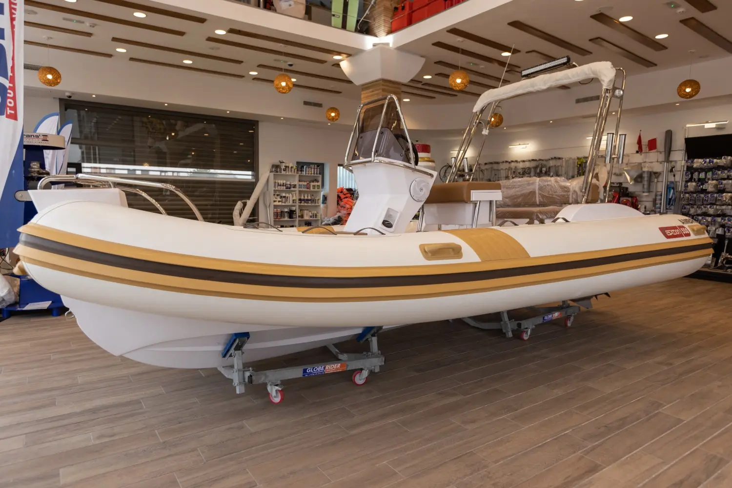 Espadon 550 — Bateau pneumatique blanc et beige présenté sur sa remorque dans un magasin.