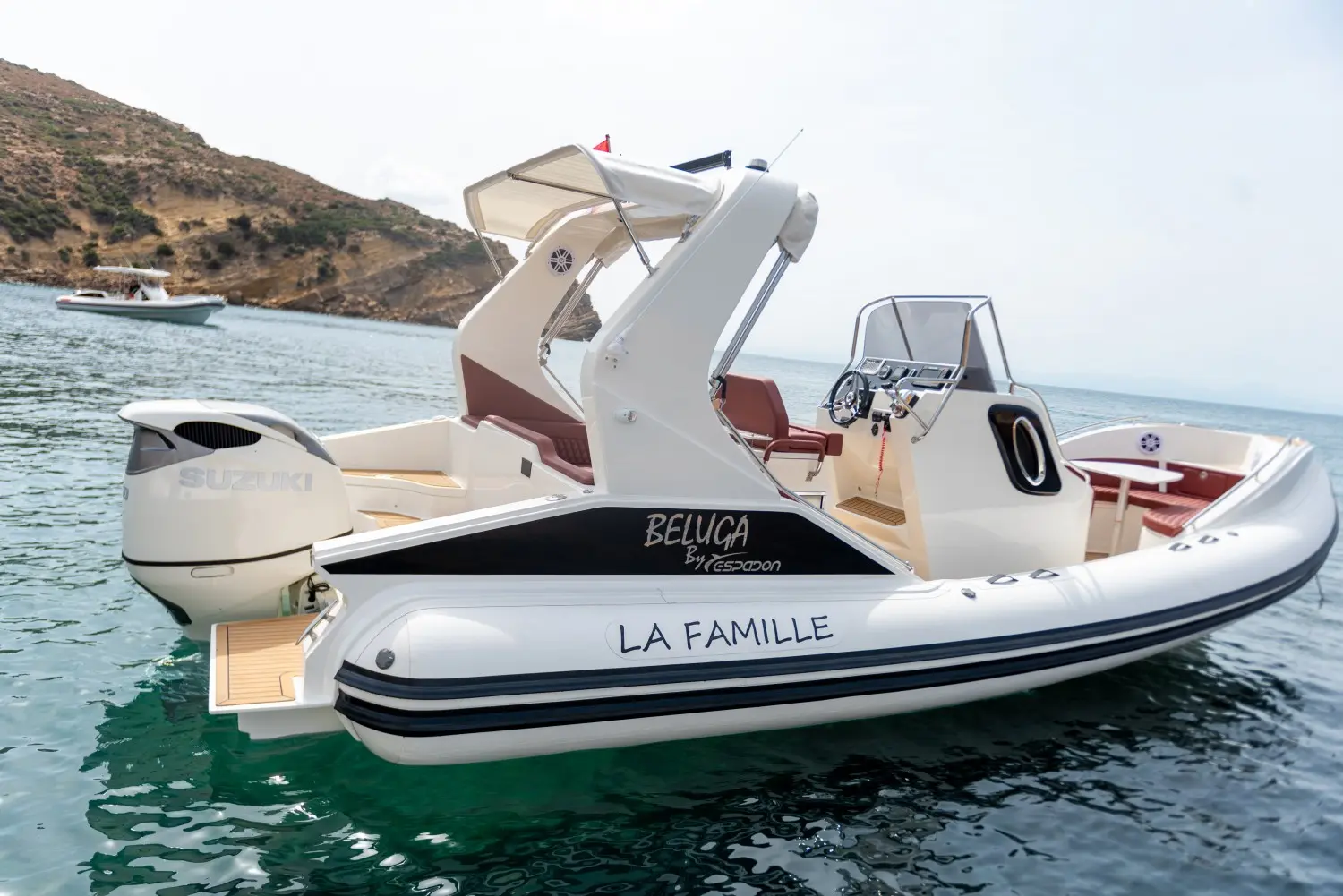 Espadon 800 Beluga — Semi-rigide blanc photographié de profil sur l’eau, avec console centrale et moteur hors-bord.