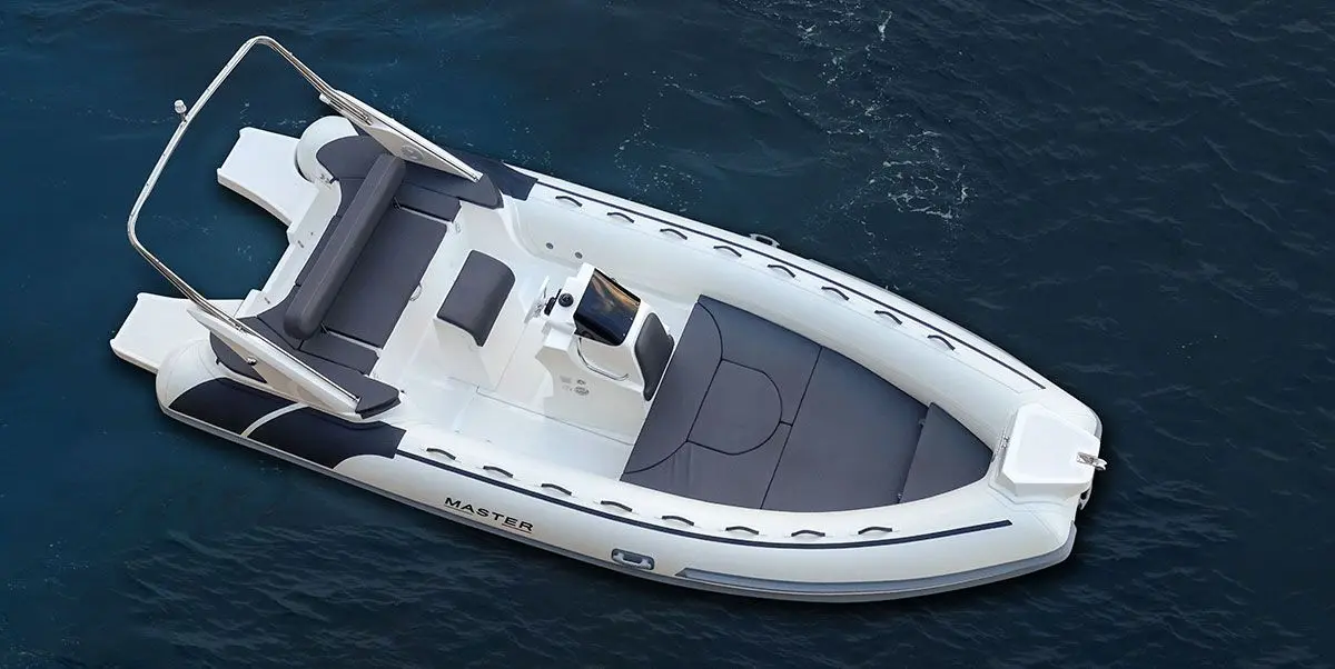 Master 630 Summer — Vue aérienne d’un bateau pneumatique blanc et gris sur l’eau.