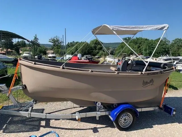 Whaly 450 — Bateau à moteur beige avec taud, présenté sur une remorque.