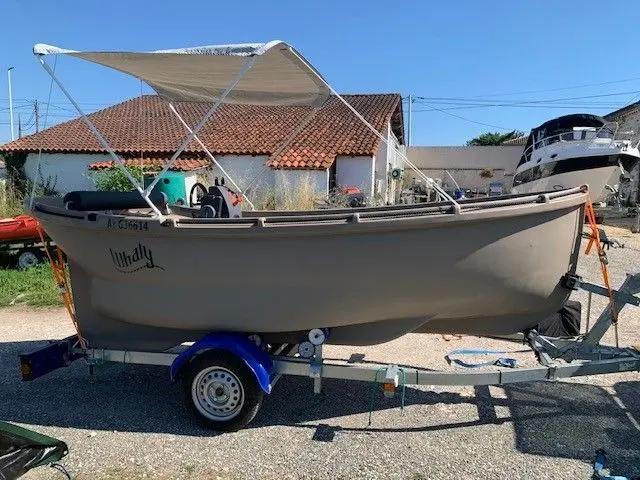 Whaly 450 — Bateau gris sur remorque, équipé d’une console centrale et d’un taud de soleil.