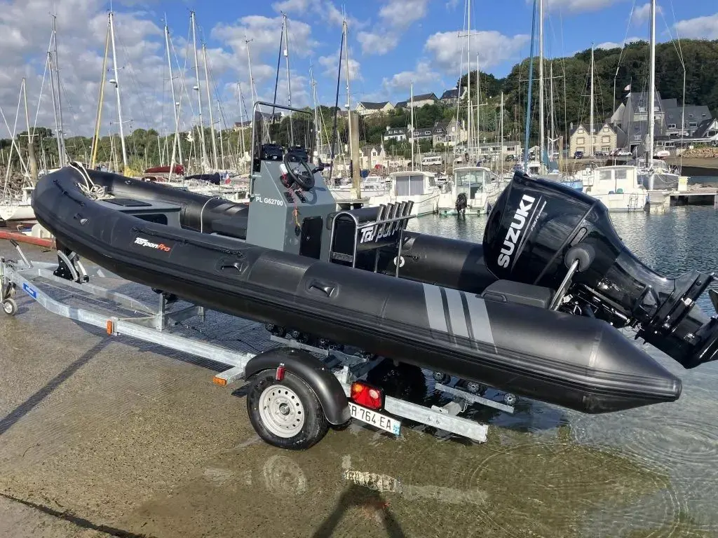 Tarpon DV65 — Bateau semi-rigide noir exposé sur remorque dans un port de plaisance.