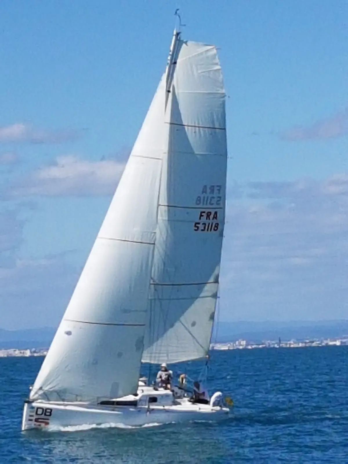 Maree Haute Django 8S — Voilier naviguant sous voiles au large, avec équipage à bord.