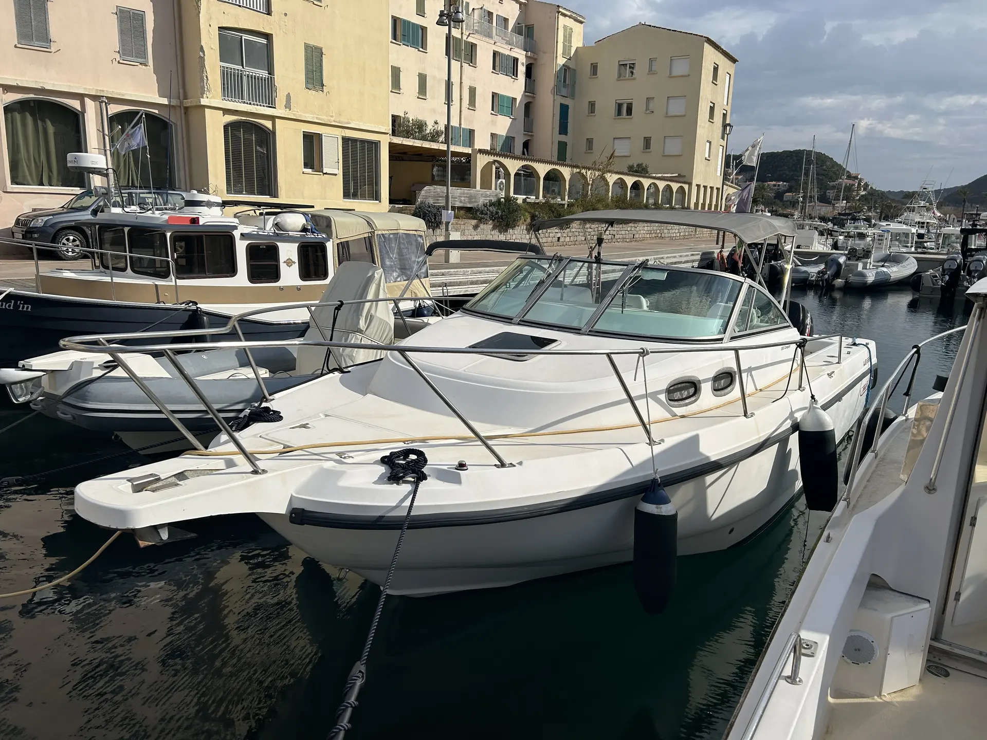 Boston Whaler 28 Conquest — Bateau à moteur blanc amarré dans un port, vu de trois quarts avant.