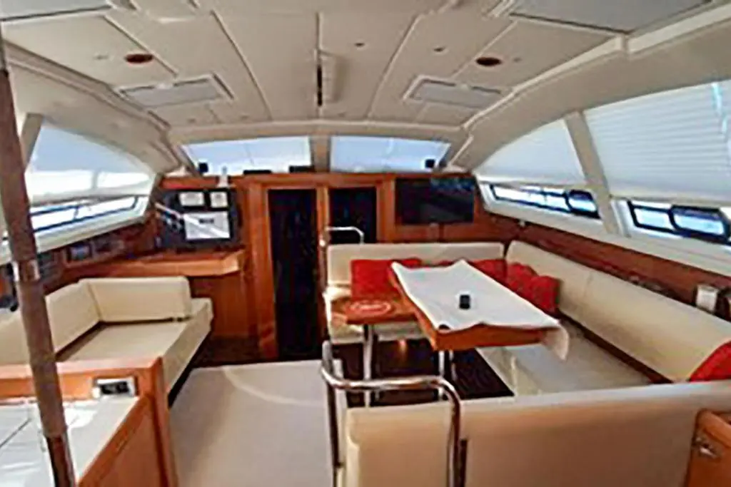Wauquiez Pilot Saloon 55 — Vue du salon intérieur avec table, banquettes et poste de navigation.
