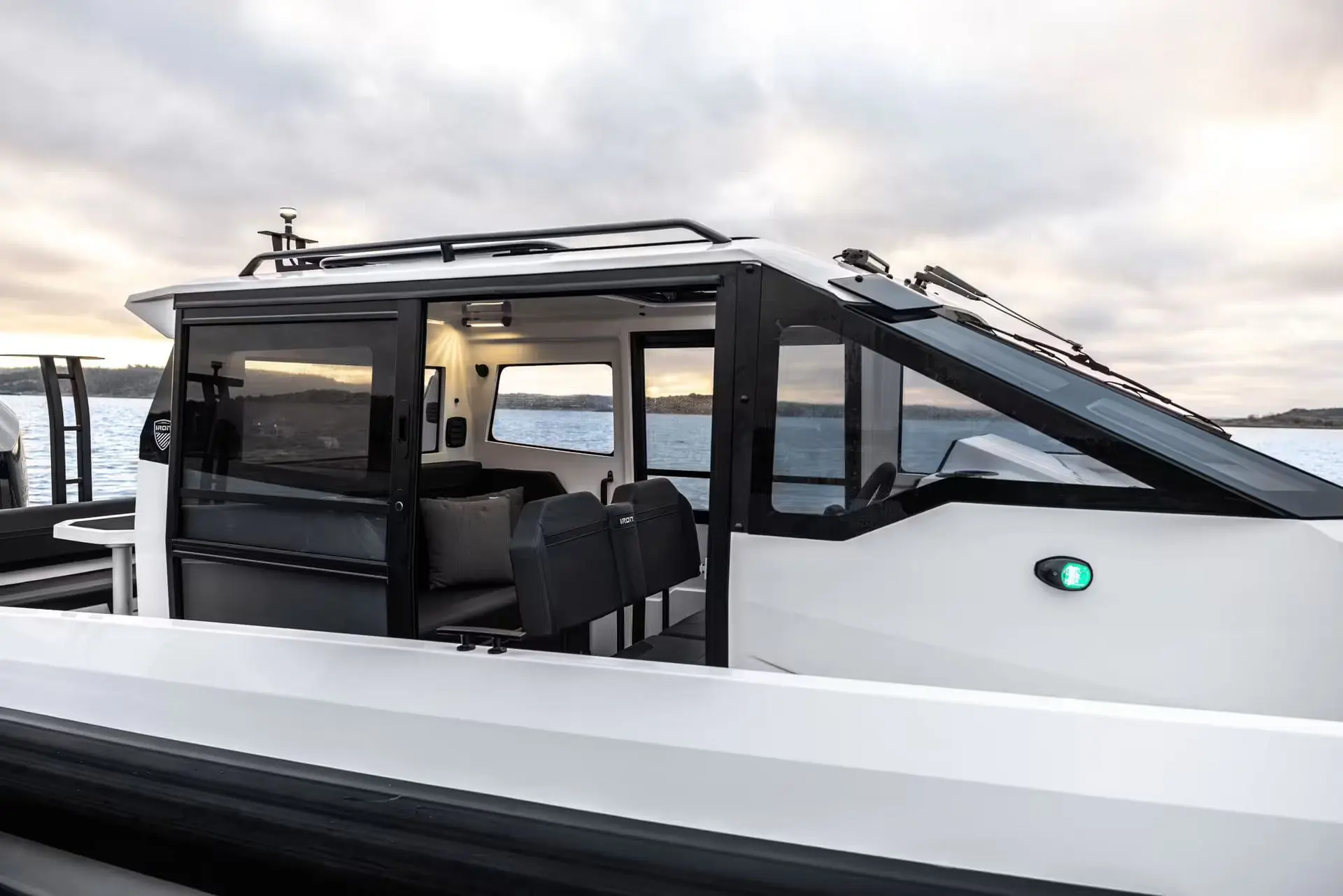 Iron Boats 907 Coupe — Vue rapprochée de trois quarts d’un bateau à cabine sur une étendue d’eau.