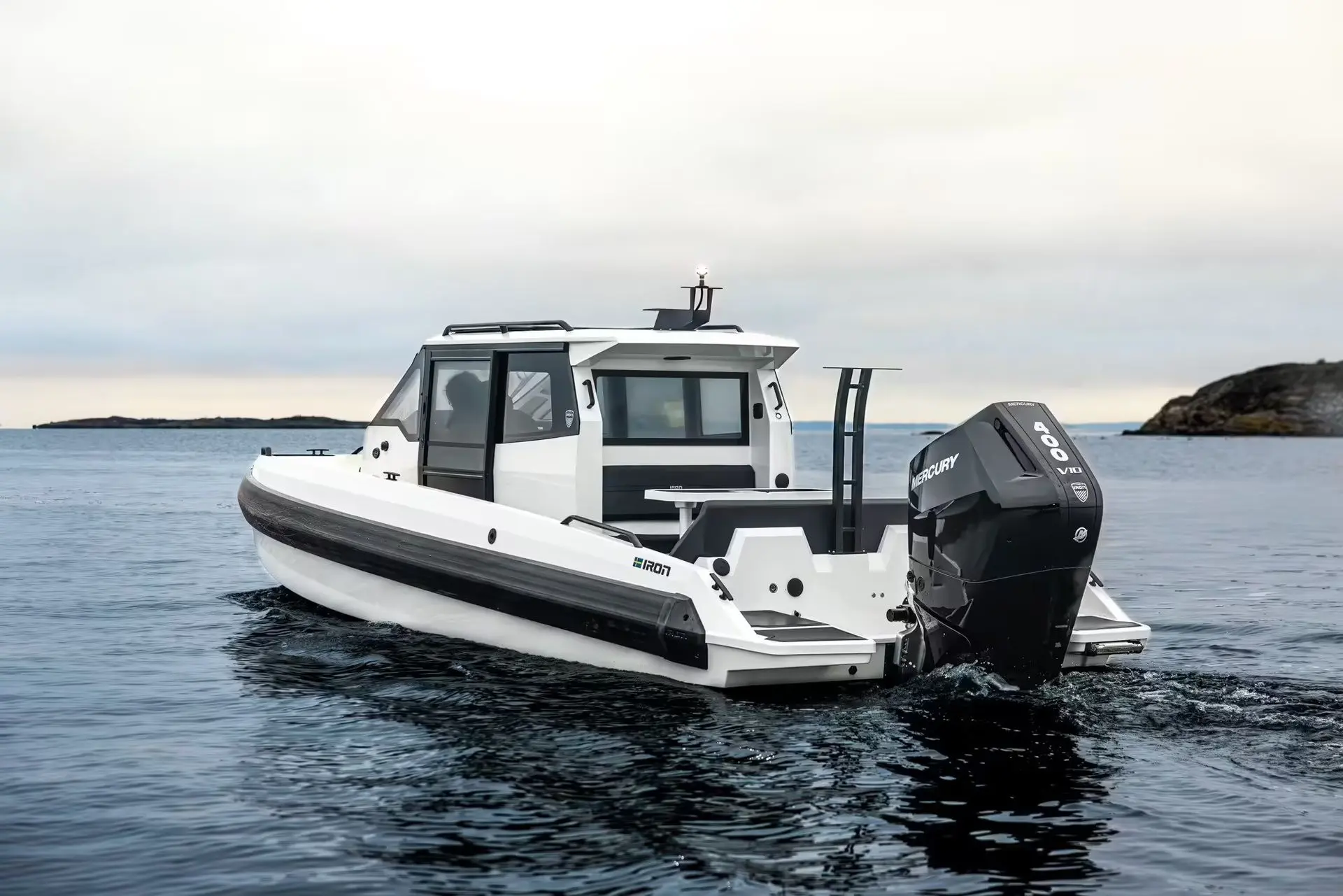Iron Boats 907 Coupe — Bateau à cabine blanche photographié de trois quarts arrière sur une mer calme.