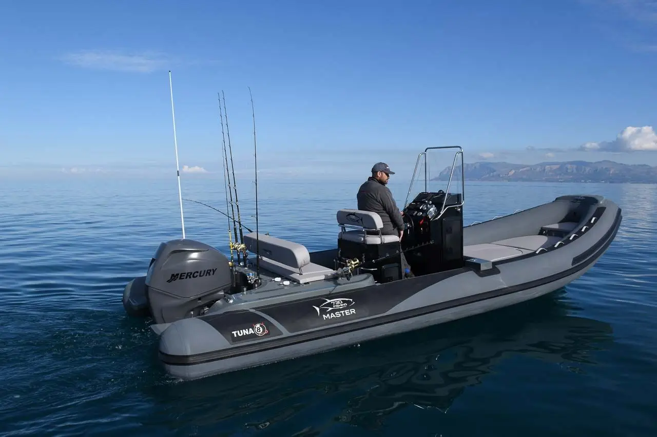 Master 730 — Bateau semi-rigide gris équipé d’un moteur hors-bord, photographié sur une mer calme.