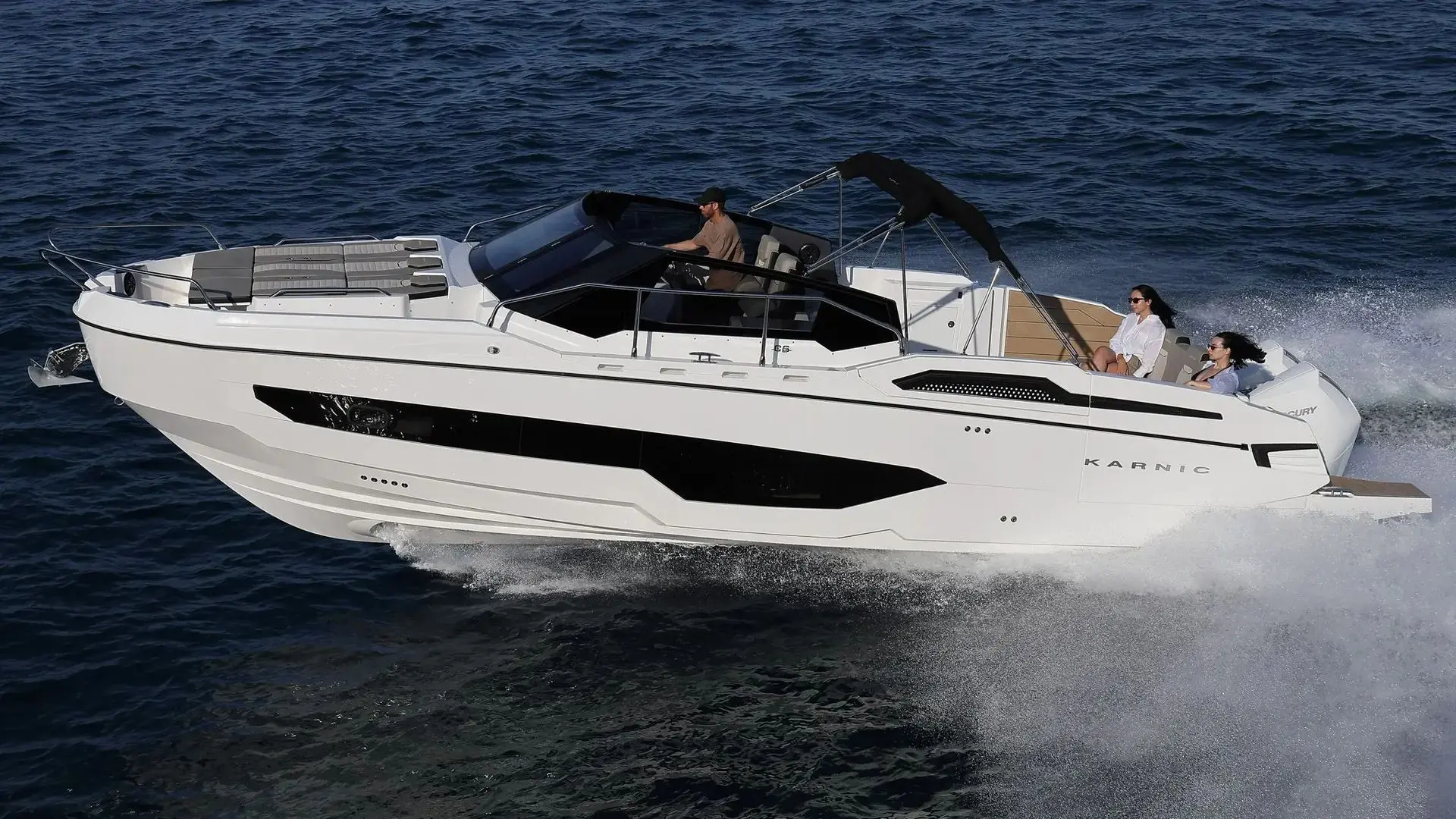 Karnic CS10 — Bateau à moteur blanc naviguant rapidement en mer avec trois personnes à bord.