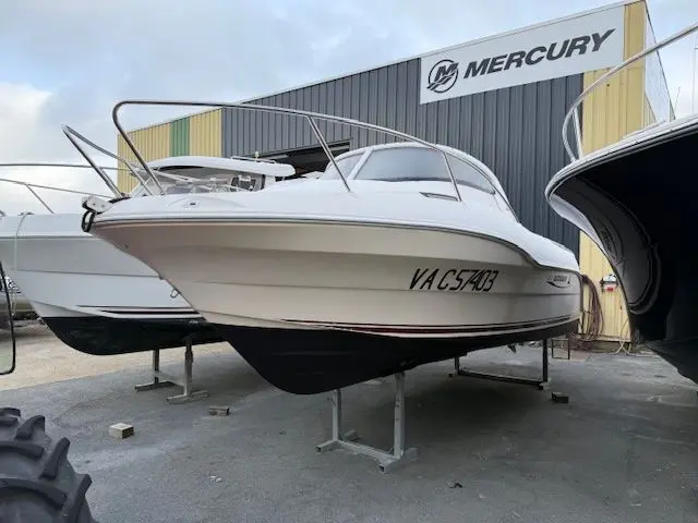 Quicksilver 620 CRUISER — Bateau à moteur blanc photographié à terre, vu de trois quarts avant.