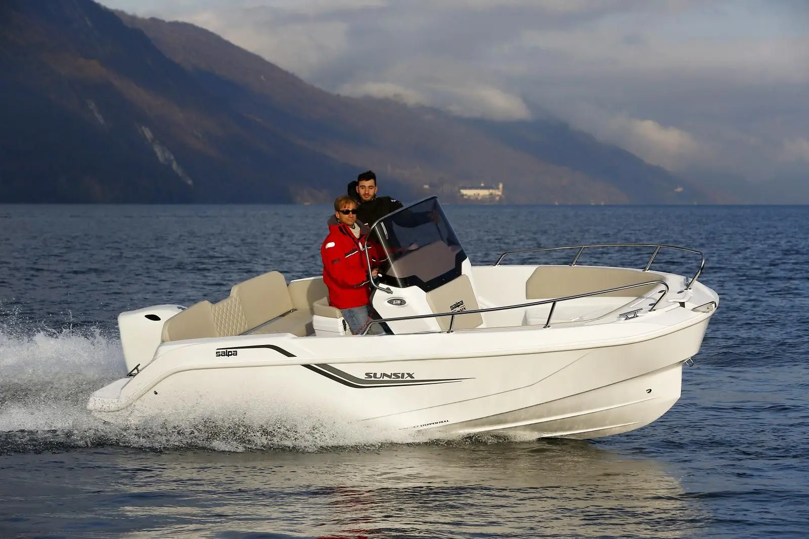 Salpa Sunsix 20 — Bateau à moteur blanc naviguant sur un lac, avec deux personnes à bord.