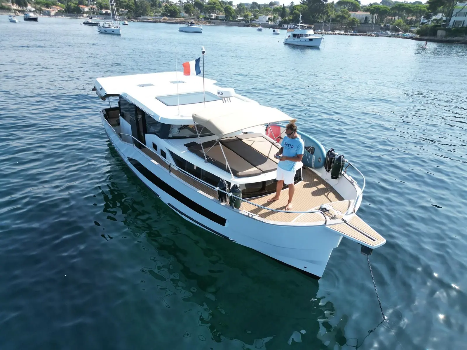 Delphia 1200 Bluescape — Bateau à moteur blanc vu de trois quarts dans une baie, avec une personne à l’avant.