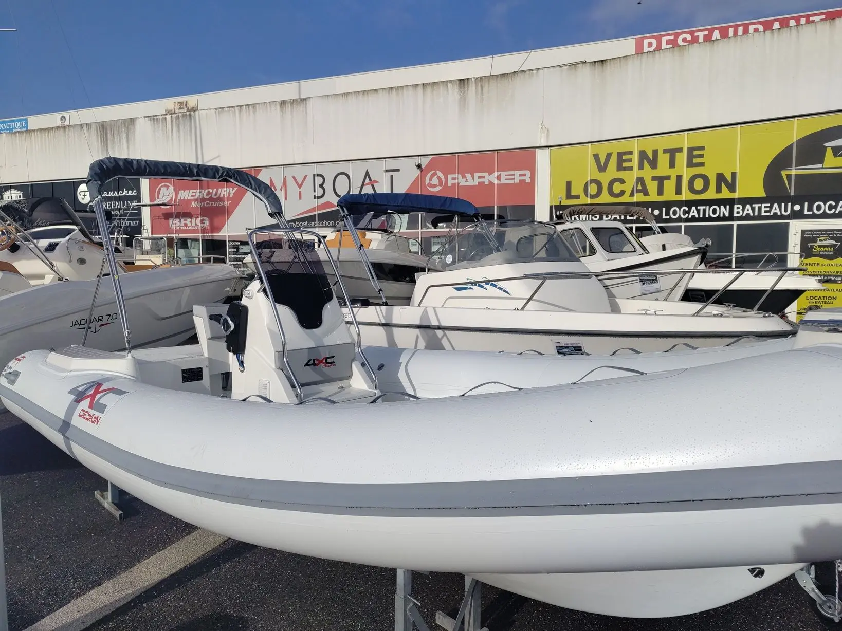 4XC HA20 — Bateau pneumatique blanc présenté sur un parc d’exposition nautique.