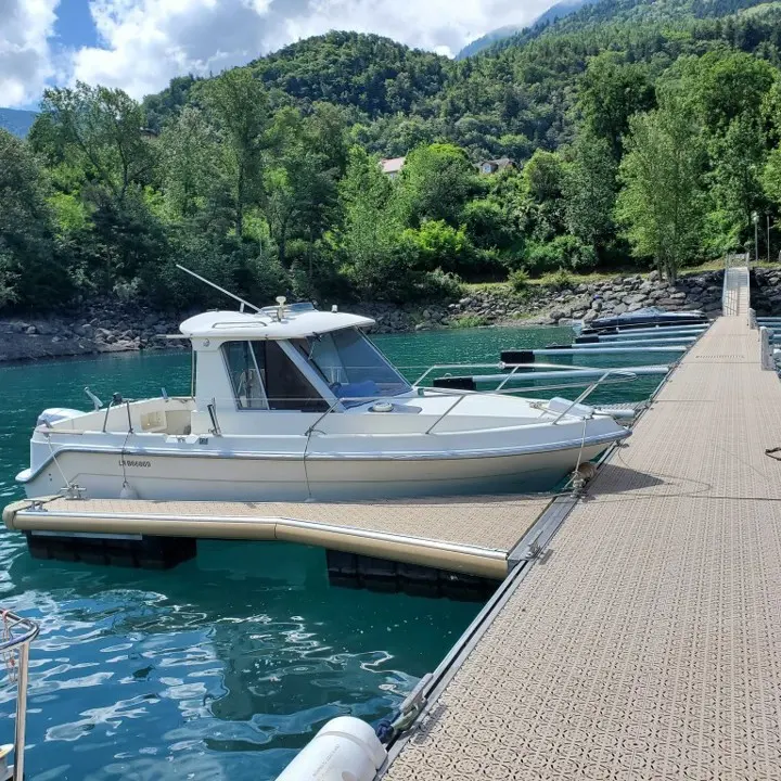 Guymarine GM 640 — Bateau à cabine amarré à un ponton sur un lac entouré de montagnes.